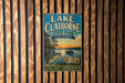 A vintage metal sign for Lake Claiborne State Park in Louisiana, featuring an illustration of a lake, trees, and a fish.