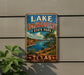 A vintage-style metal sign with the text "LAKE COLORADO CITY STATE PARK TEXAS" and a scenic landscape depicting a lake, mountains, and trees.