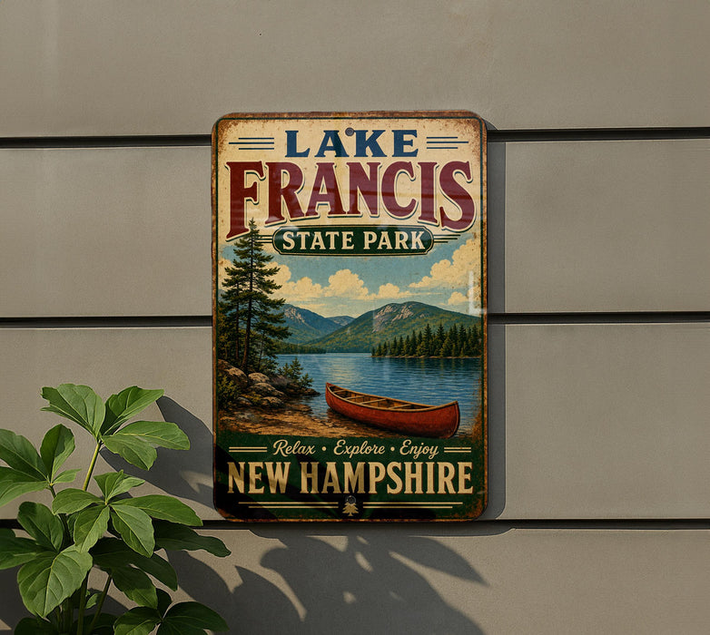 A vintage-style metal sign for Lake Francis State Park in New Hampshire, featuring a scenic image of a lake with a canoe and mountains in the background.