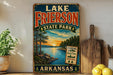 A vintage-style sign for Lake Frierson State Park in Arkansas, featuring a scenic landscape with a lake, trees, and a sunset.