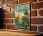 A vintage metal sign for Lake Griffin State Park in Florida, featuring a scenic illustration of a bird and palm trees against a sunset backdrop.