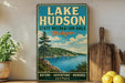 A vintage-style sign for Lake Hudson State Recreation Area in Michigan, featuring a scenic landscape with a lake, mountains, and pine trees.