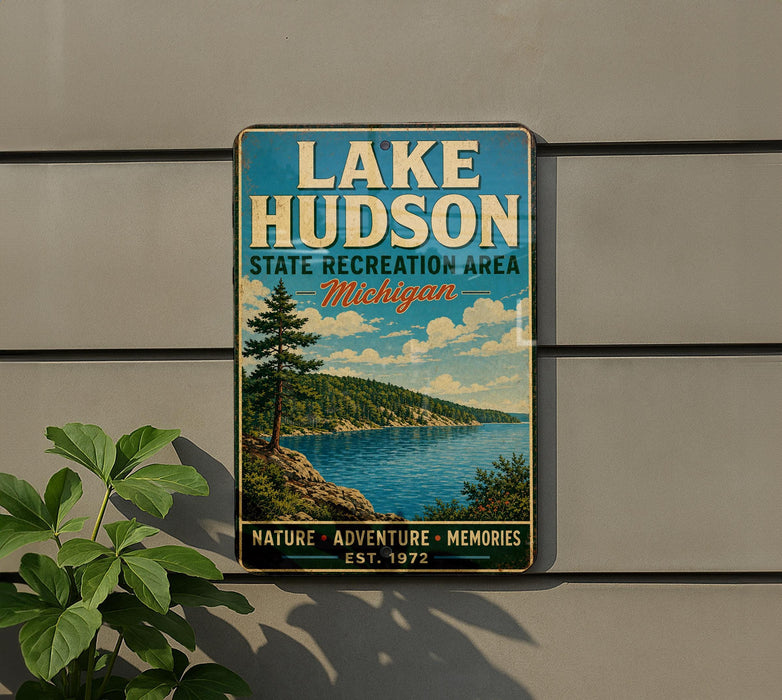 A vintage metal sign for Lake Hudson State Recreation Area in Michigan, featuring a scenic landscape with a lake, mountains, and pine trees.