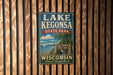 A vintage metal sign for Lake Kegonsa State Park in Wisconsin, featuring a scenic image of the lake and surrounding landscape.
