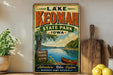 A vintage-style sign for Lake Keomah State Park in Iowa, featuring a scenic image of a lake, trees, and a canoe.