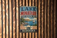 A vintage metal sign for Lake Minatare State Recreation Area in Nebraska, featuring a scenic image of a lake with a sailboat and mountains in the background.