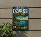 A vintage-style sign for Lake of the Ozarks State Park in Missouri, featuring a scenic landscape with a lake, mountains, and a boat.
