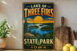 A vintage-style sign for Lake of Three Fires State Park in Iowa, featuring a scenic landscape with a lake, forest, and sunset.
