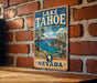 A vintage-style sign for Lake Tahoe, Nevada State Park, mounted on a brick wall.