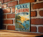 A vintage-style sign for Lake Tawakoni State Park in Texas, featuring a scenic illustration of a lake, a sailboat, and a sunset.