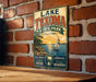 A vintage-style sign for Lake Texoma State Park in Oklahoma, featuring a sailboat on a lake and the text "Real Oklahoma. Explore Nature. Adventure. Make Memories."