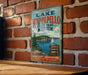 A vintage metal sign for Lake Wippespelco State Park in Missouri, featuring a scenic image of the lake and surrounding landscape.