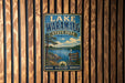A vintage-style metal sign for Lake Waramaug State Park, featuring a scenic landscape with a lake, mountains, and pine trees.