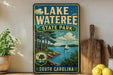 A vintage-style sign for Lake Wateree State Park in South Carolina, featuring a scenic illustration of a lake, trees, and a sailboat.