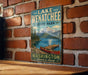 A vintage-style metal sign for Lake Wenatchee State Park, featuring a scenic illustration of a lake, mountains, and a canoe.