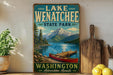A vintage-style sign for Lake Wenatchee State Park in Washington, featuring a scenic image of a lake, mountains, and a red canoe.