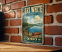 A vintage-style metal sign for Lake White State Park in Ohio, featuring a scenic image of a lake with a canoe and mountains in the background.