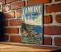 A vintage-style metal sign for Lamoine State Park in Maine, featuring a scenic coastal landscape with pine trees, rocks, and a body of water.