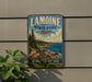 A vintage-style metal sign for Lamoine State Park in Maine, featuring a scenic coastal landscape with pine trees, rocks, and a body of water.
