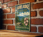 A vintage-style metal sign for Laurel Ridge State Park in Pennsylvania, featuring a scenic landscape with mountains, trees, and flowers.