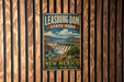 A vintage-style metal sign for Leasburg Dam State Park in New Mexico, featuring a scenic landscape with a dam and mountains in the background.
