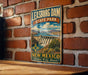 A vintage-style metal sign for Leasburg Dam State Park in New Mexico, featuring a scenic landscape with a dam and mountains in the background.