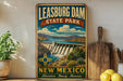 A vintage-style sign for Leasburg Dam State Park in New Mexico, featuring a scenic illustration of the dam and surrounding landscape.
