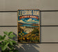 A vintage-style metal sign for Leasburg Dam State Park in New Mexico, featuring a scenic illustration of the dam and surrounding landscape.