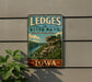 A vintage-style metal sign for LEDGES STATE PARK in Iowa, featuring a scenic landscape with a rocky cliff and a river.