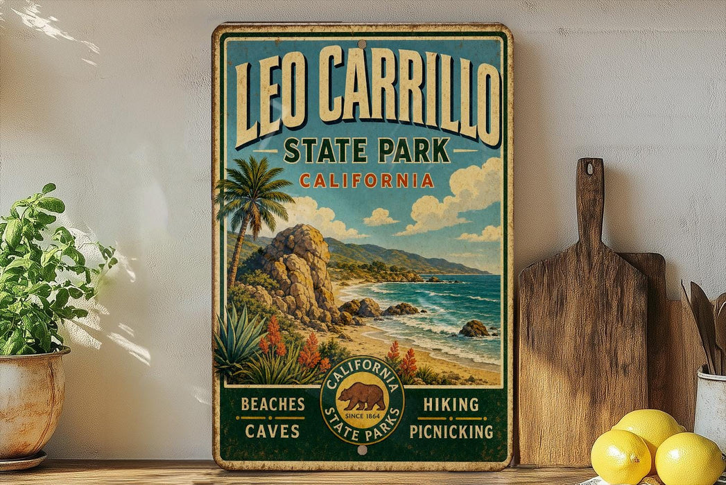 A vintage-style sign for Leo Carrillo State Park, California, featuring a beach, palm trees, and mountains.