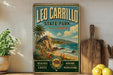 A vintage-style sign for Leo Carrillo State Park, California, featuring a beach, palm trees, and mountains.