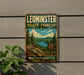 A vintage-style metal sign for Leominster State Forest in Massachusetts, featuring a scenic landscape with pine trees, a lake, and mountains.