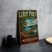 A vintage-style metal sign for LeRoy Percy State Park in Mississippi, featuring a scenic landscape with a wooden bridge and a lake.