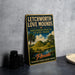 A vintage-style sign for Lechworth-Love Mounds, an archaeological state park in Florida, featuring a tropical landscape with palm trees and hills.