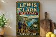 A vintage-style sign for Lewis and Clark State Park in Missouri, featuring a scenic illustration of the park's landscape and two figures in historical attire.