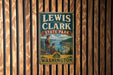 A vintage-style metal sign for Lewis and Clark State Park in Washington, featuring a scenic illustration of the park's landscape.