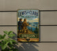 A vintage metal sign for the Lewis and Clark State Recreation Site in Oregon, featuring two hikers on a trail overlooking a scenic landscape.