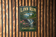 A vintage metal sign for Linn Run State Park in Pennsylvania, featuring a scenic image of a waterfall surrounded by nature.