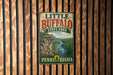 A vintage metal sign for Little Buffalo State Park in Pennsylvania, featuring a scenic landscape with a river, cliffs, and flowers.