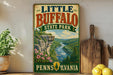 A vintage-style sign for Little Buffalo State Park in Pennsylvania, featuring a scenic illustration of a river and mountains.