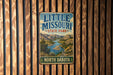 A vintage metal sign for Little Missouri State Park, featuring a scenic landscape with a river and mountains.