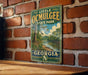 A vintage-style metal sign for Little Ocmulgee State Park in Georgia, featuring a scenic landscape with a river and trees.