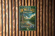 A vintage metal sign for Little Ocmulgee State Park in Georgia, featuring a scenic landscape with a river and trees.