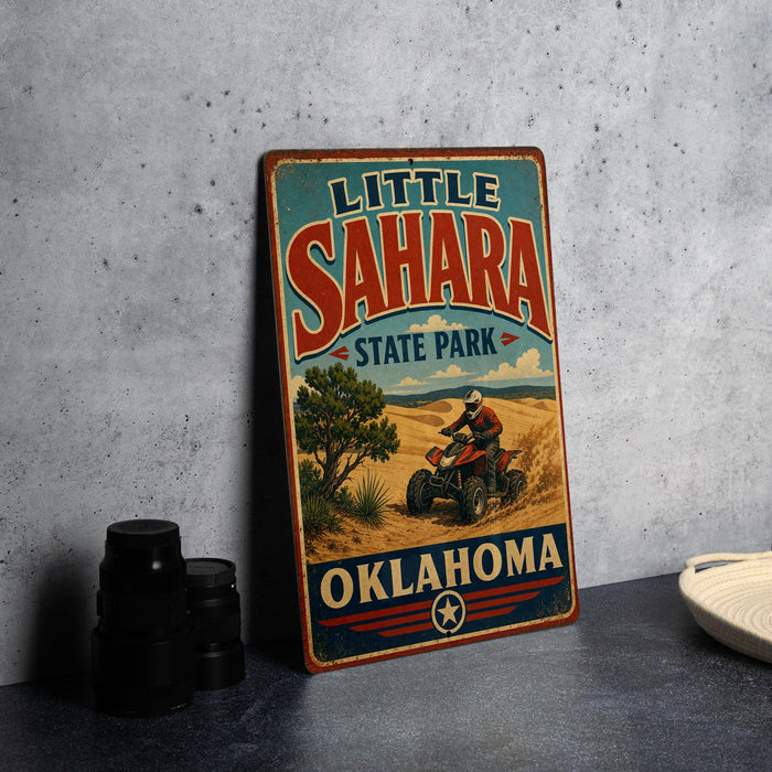 A vintage-style metal sign for Little Sahara State Park in Oklahoma, featuring an illustration of a person riding an ATV in a desert landscape.