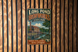 A vintage metal sign for Long Pond Ironworks State Park in New Jersey, featuring an illustration of a building and a pond.