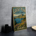 A vintage-style sign for Lucky Peak State Park in Idaho, featuring a scenic landscape with mountains, a lake, and colorful wildflowers.