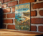 A vintage metal sign for Mackerricher State Park in California, featuring a scenic coastal landscape with rocky cliffs, ocean waves, and wildflowers.