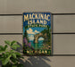A vintage-style metal sign for Mackinac Island State Park in Michigan, featuring a scenic landscape with a natural arch and a body of water.