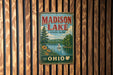 A vintage metal sign for Madison Lake State Park in Ohio, featuring a scenic landscape with a lake, trees, and a sailboat.