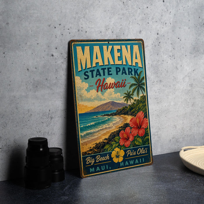 A vintage-style metal sign for Makena State Park in Hawaii, featuring a tropical beach scene with palm trees, flowers, and a mountain in the background.